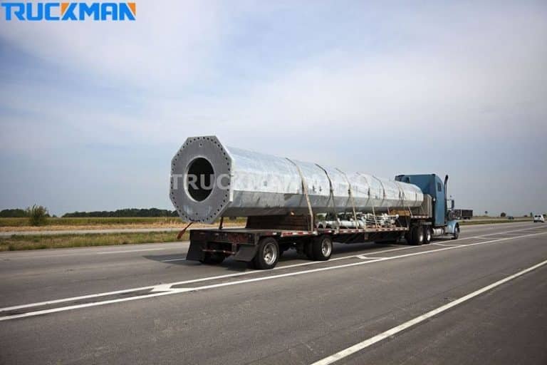 Low chassis semi-trailer transporting large industrial building components on motorway