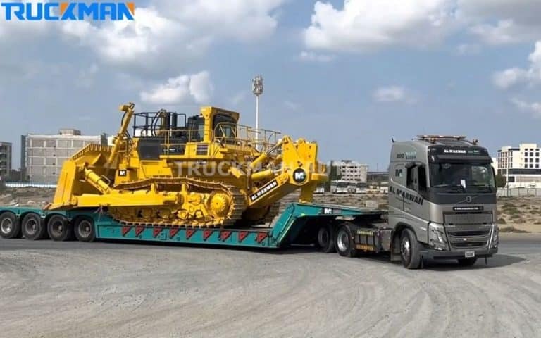 Low-bed semi-trailer truck loading a large yellow excavator - rugged construction and transport efficiency