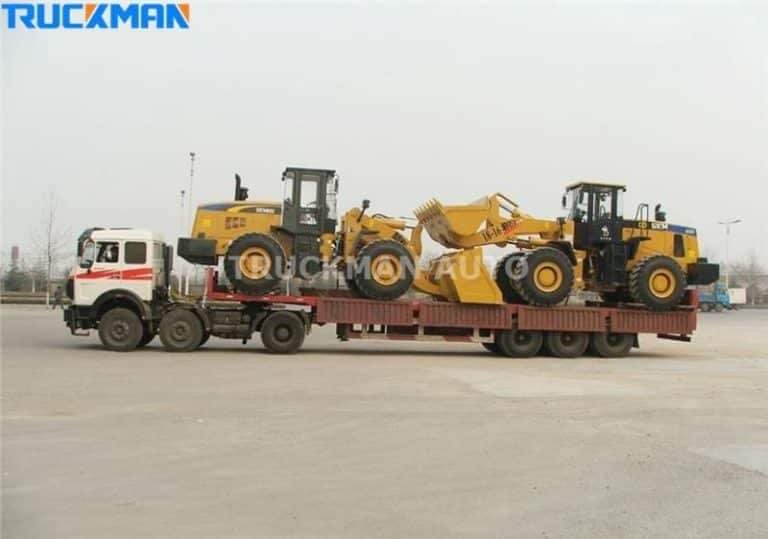 Low-bed semi-trailer loaded with yellow construction machinery - versatility in transporting construction and agricultural equipment